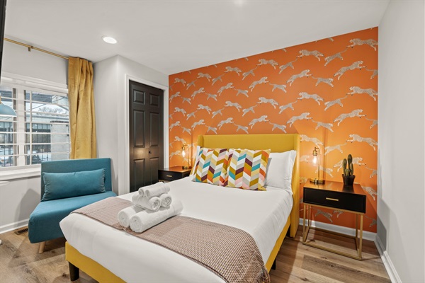 Bright, joyful energy fills this stylish bedroom with bold wallpaper, luxe bedding, and space to unwind.