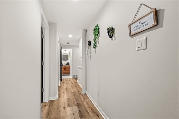 Bright, inviting hallway accented with greenery — a touch of calm that leads you toward spa-like comfort.