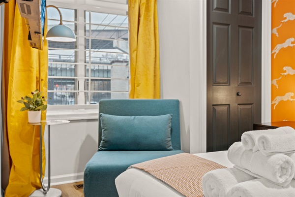 A sunny nook with a teal chair and gold curtains—perfect for morning coffee, reading, or quiet reflection.