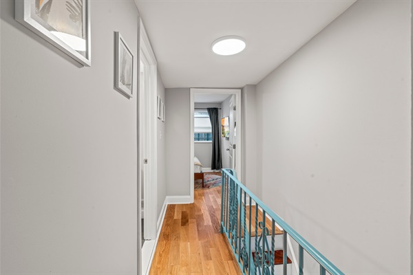 Bright upper hallway guiding you toward the serene main bedroom suite.