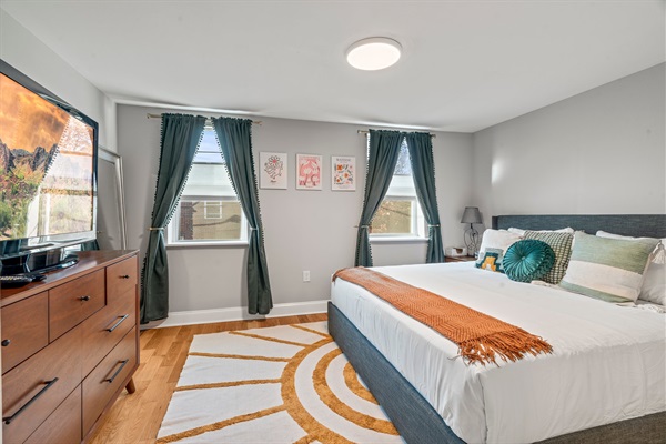 Spacious primary bedroom with a king bed, chic decor, and plenty of natural light.