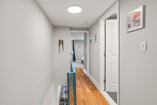 Light-filled hallway with clean lines and hardwood floors leading to the bedrooms and bath.