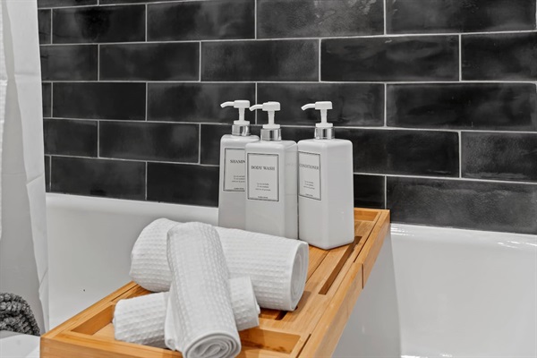 You will love the luxurious bathroom amenities, including high-quality shampoo, conditioner, and body wash. The stylish black-tiled backdrop adds a touch of elegance to your daily routines.