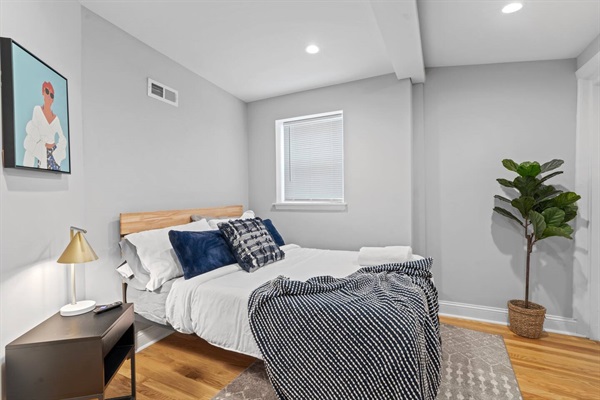Unwind in this spacious, well-lit bedroom. The blend of modern and cozy elements, including a comfortable bed and tasteful decor, ensures a restful and pleasant stay for you.
