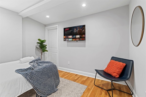Appreciate the blend of comfort and convenience in this bedroom. With a large, comfy bed and wall-mounted TV, it's an ideal spot to relax, watch your favorite shows, and recharge.