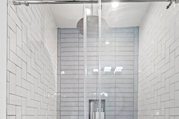 Step into luxury in this elegant shower area, boasting contemporary tiling and a spacious layout. The rainfall showerhead ensures a spa-like experience, making it a delightful feature of your stay.