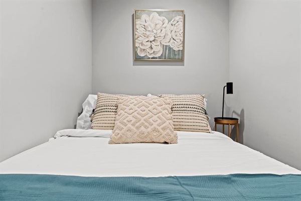 You will love the serene charm of this cozy bedroom. The elegant floral artwork and plush pillows create a restful retreat, perfect for a good night's sleep after a day of exploring the city.