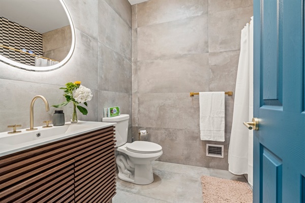 Modern tile and designer gold finishes in this gorgeous bathoorm!